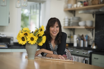 Karen at a table with flowers in vase.