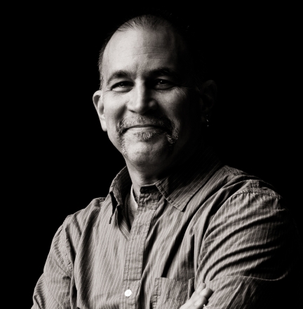 B & W photo, person in buttondown shirt, short hair.