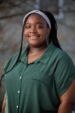 Photo of Photo of Artrianna Freeman wearing a dark green shirt and a grey headband.