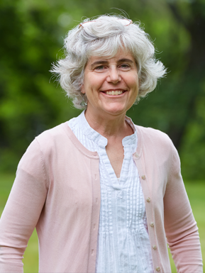 Photo of Kim Balparda wearing a white blouse with a light pink sweater. 