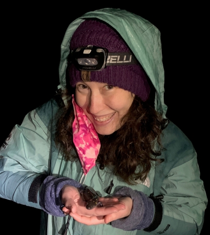 woman smiling, in winter clothes holding salamander