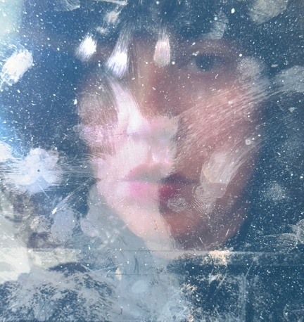 portrait of woman through dust speckled laptop screen