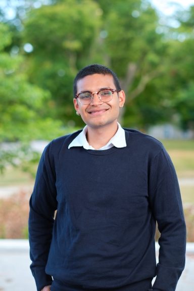 A photograph of Yuvraj Shah standing outside and smiling at the camera