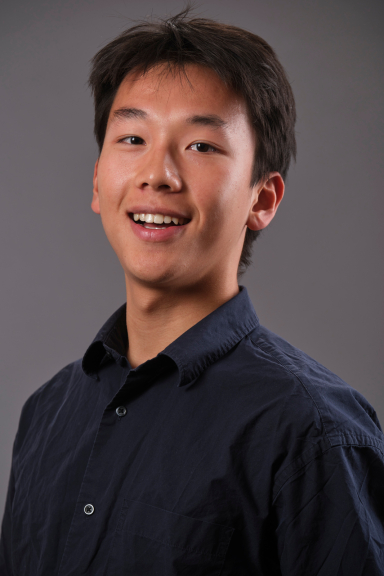 A photograph of Owen Ou, wearing a black button-down shirt and smiling at the camera