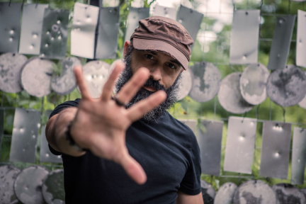 kyle saulnier, smoldering toward the camera through outstretched fingers