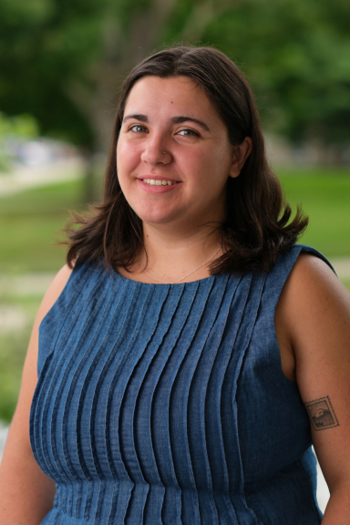 A photograph of Catherine Heckler, wearing a blue top and smiling at the camera.