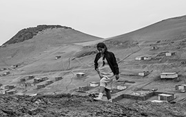 Song Without a Name Image of woman walking alone across rocky field