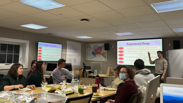 A student presents his linguistics senior thesis research using a projector.