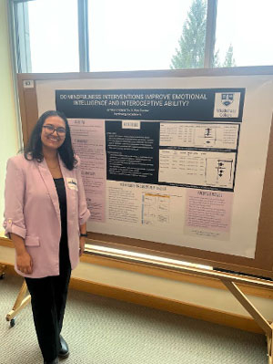 Student stands by her poster.