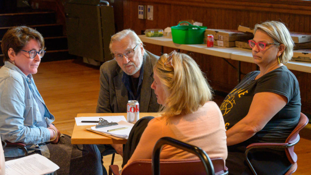 People talking around a table with papers in front of them.