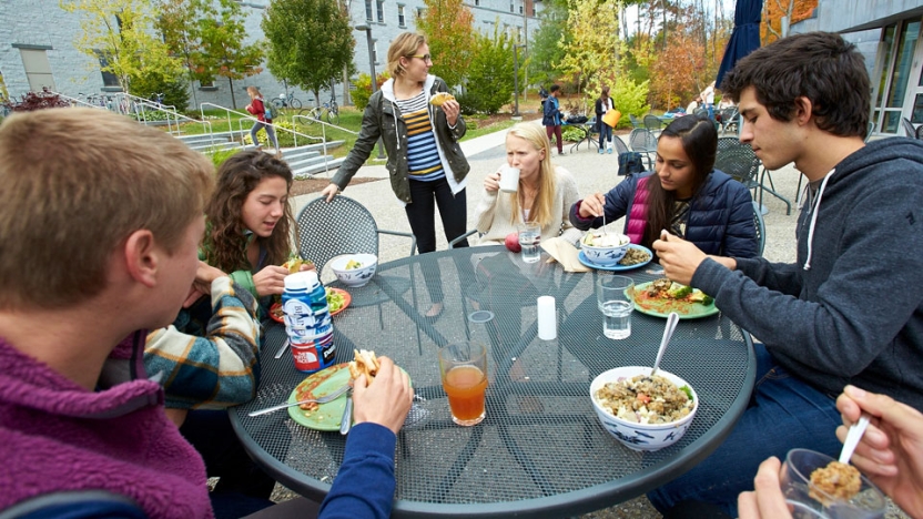 Eight students eating lunch on ourdoor patio.