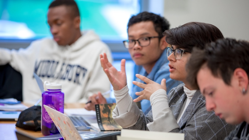 A close-up of several students in a classroom discussion. 