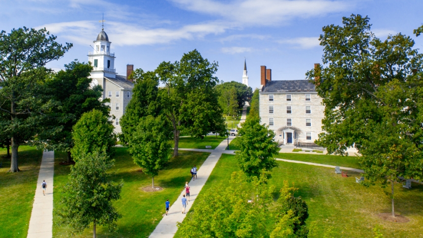 View of campus with students walking on the sidewalk.