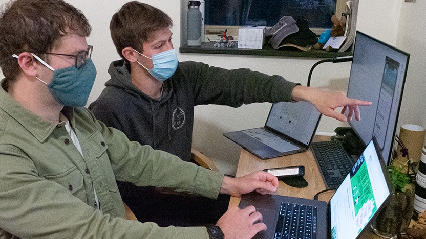 Two students sit in front of computer prepping for Eat Local VT.