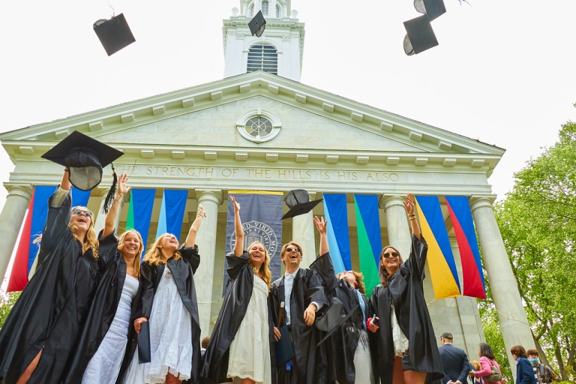 students in front of Middlebury chapel, tossing their mortar boards in the air