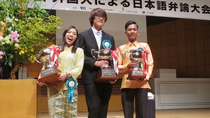 Three students pose with their awards after winning the speech contest