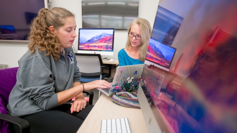 A professor works with a student on her writing.