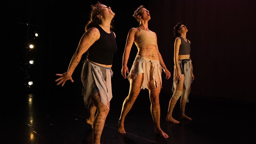 Three dancers perform on stage.