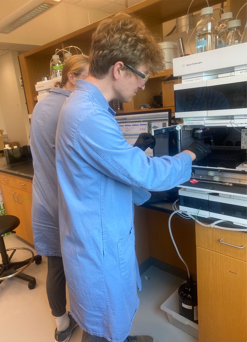 Researchers using an HPLC to purify peptides (left to right, Lucy Ambach and William Holzman)