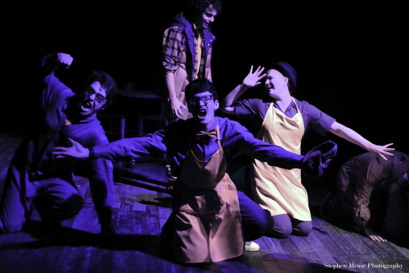 Actors in a diamond formation crouching on the ground, shouting