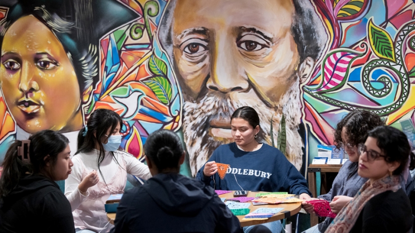 Anderson Freeman Resource Center gathering at a table doing a craft in front of a mural.