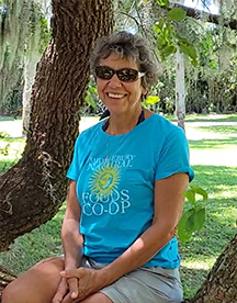 Woman with short hair, aqua blue shirt, sunglasses