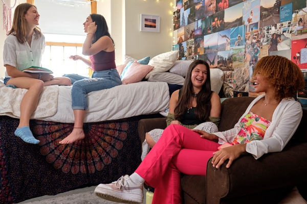 Four students hang out in a Middlebury dorm room together