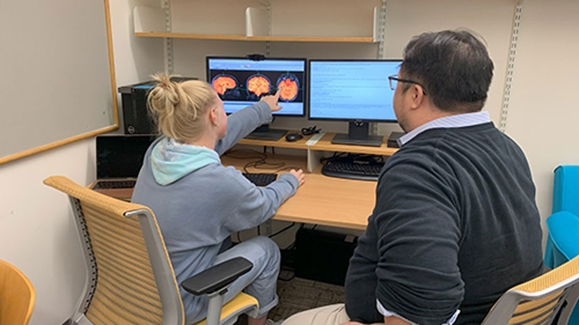 Student and faculty member working together at a computer.