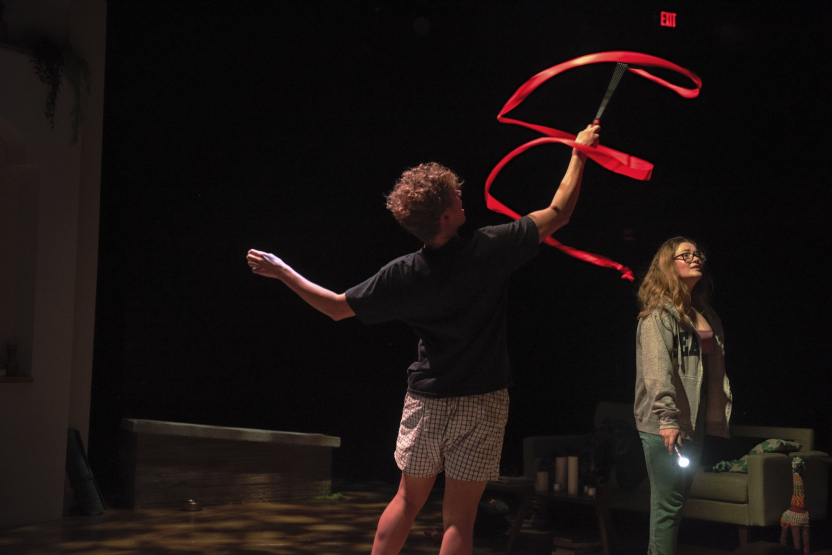 man twirling a red ribbon