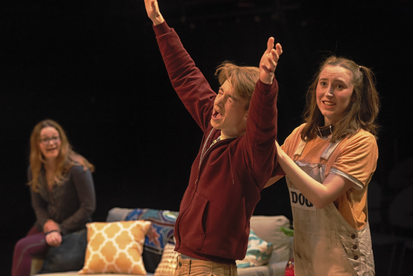man with hands in the air and girl with hands on his shoulders