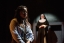 A nun out of focus in the background overlooking a school girl in the shadows