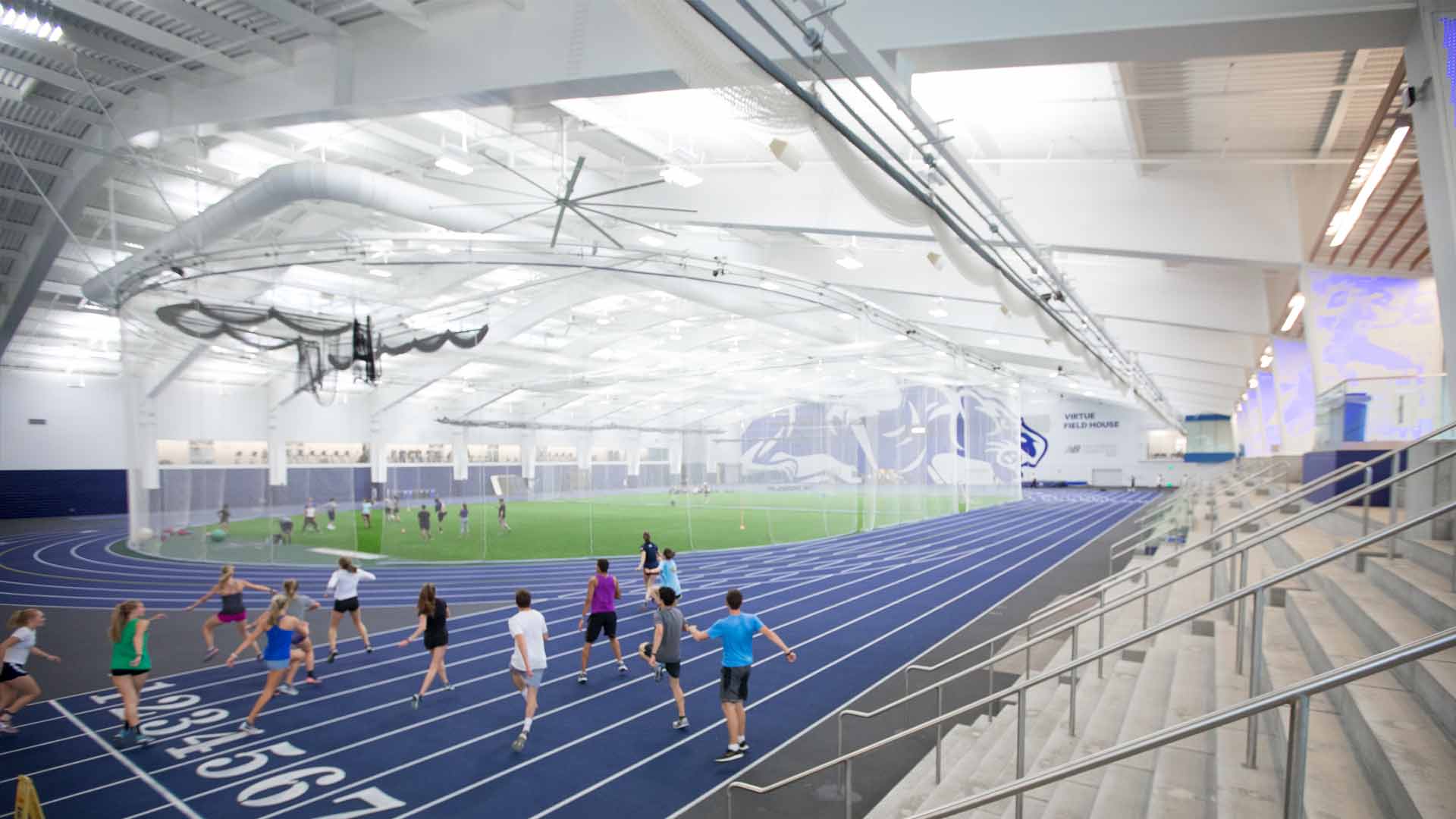 Students run and stretch on the indoor track in Virtue Fieldhouse