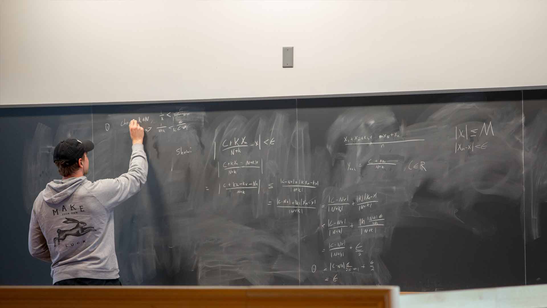 Student works at a chalkboard in BiHall.