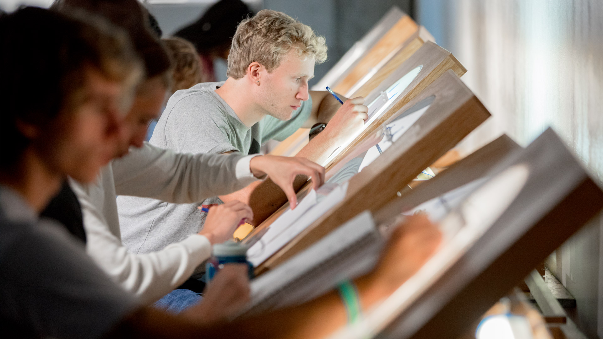 Students working at art desks in animation class.