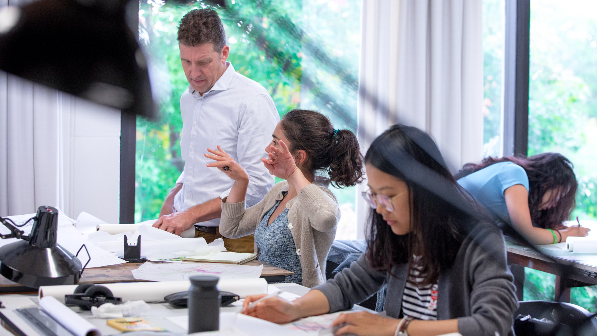 An architecture professor works one-on-one with a student in a studio class.