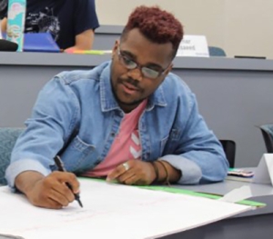 A MiddCORE Lab Intern writes on large paper.