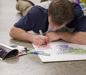 A Middlebury student write notes while working on a Social Impact project.