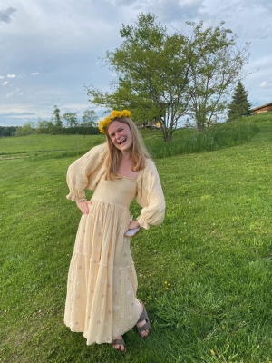 Maddy Russell standing and smiling in a field of green grass