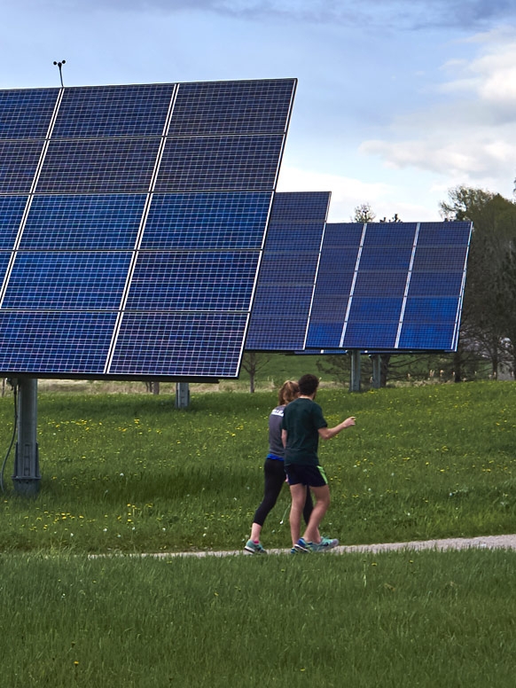 Student run on a trail around Middlebury that passes through the college's solar array.