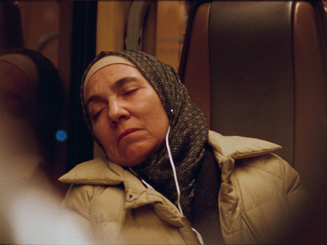 A middle aged woman asleep on a bus