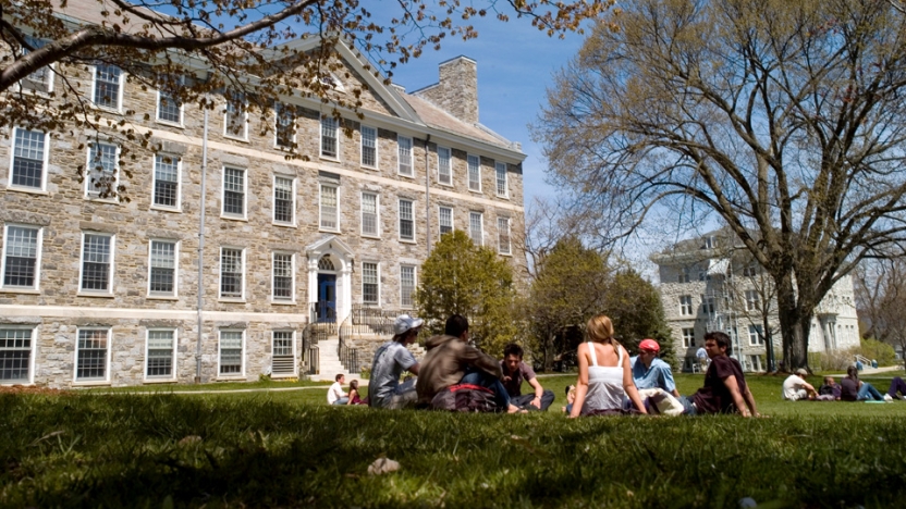 Students sitting in a circle outside a building at Middlebury College