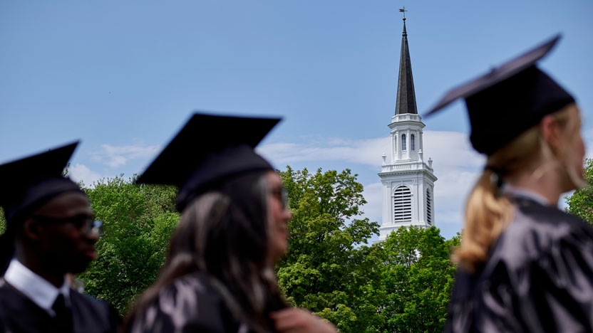 Graduates assemble with the spire of Old Chapel in the distance.