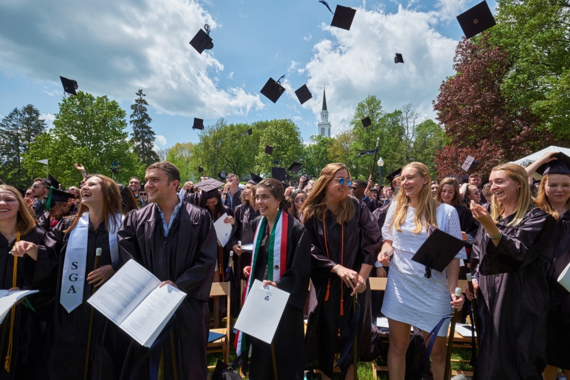 Middlebury College graduates tossing mortar boards in the air