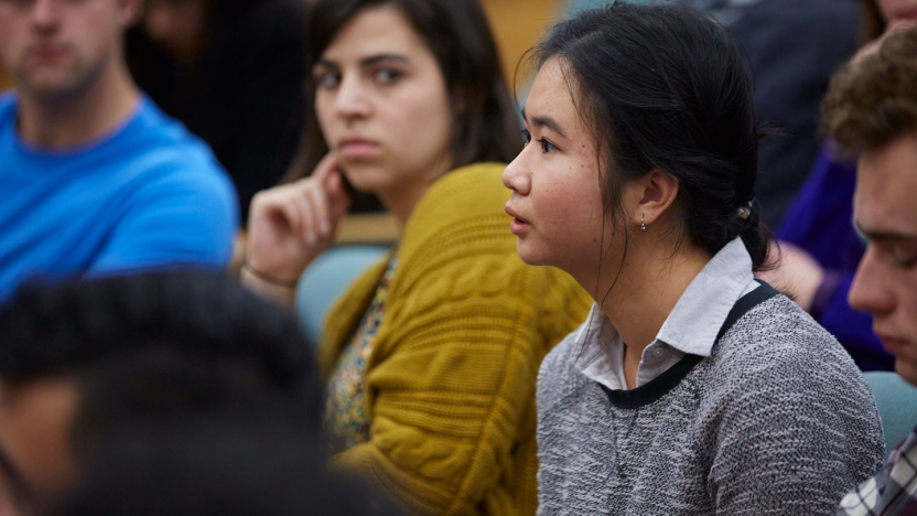 Student Ngor Luong ’19 asks the panel a question as her classmate Maddy Dickinson ’18 listens.