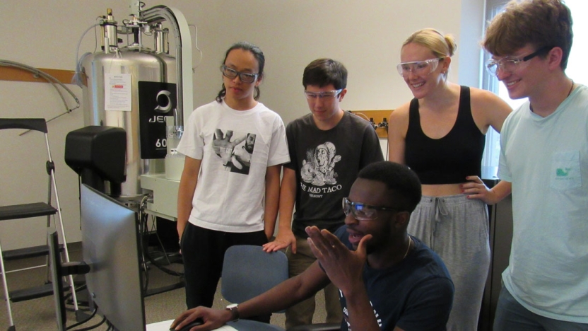Researchers discussing NMR data (left to right, Scott Li, Hans Kindstedt, Abdul Abubakari, Lucy Ambach, William Holzman)