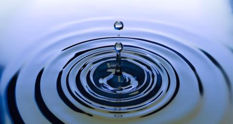 A drop of water causing a ripple effect in a pool