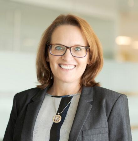 Woman with auburn hair and glasses