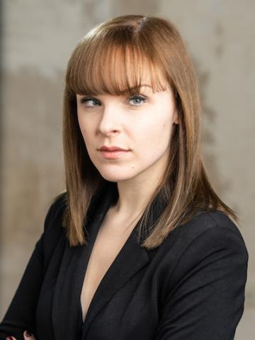 Woman with brown hair wearing a black dress