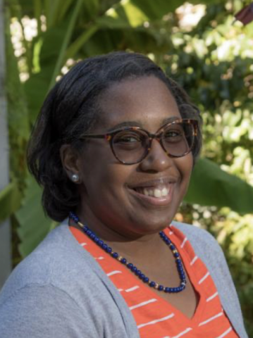 Image of a woman wearing glasses and an orange and white stripped shirt