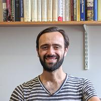 Image of a man with a beard wearing a striped shirt